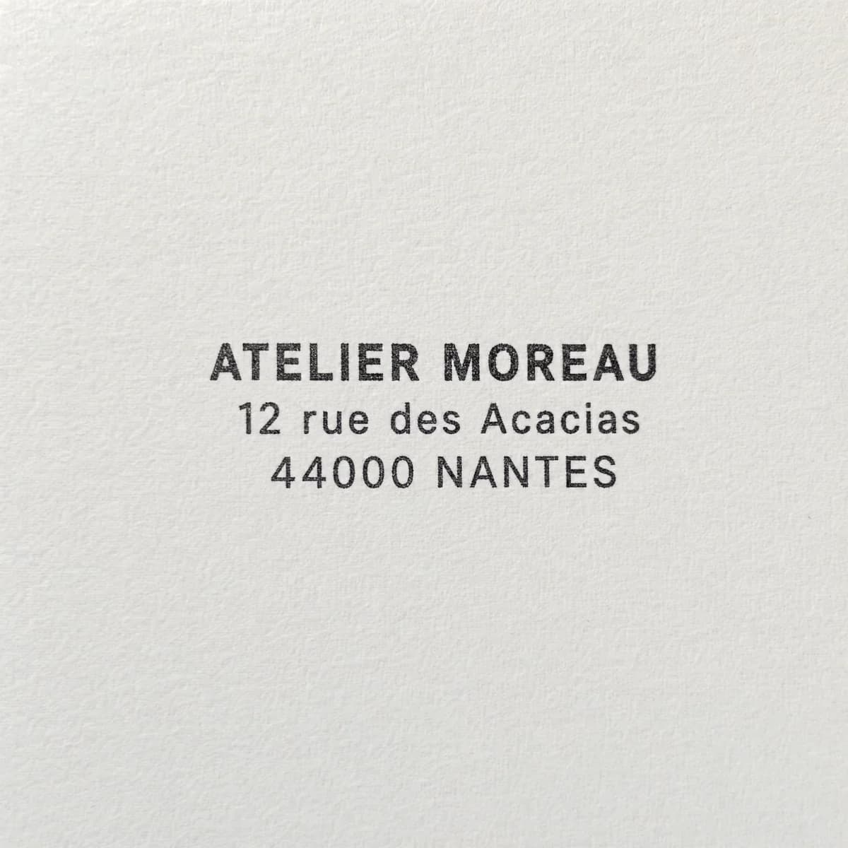 Adresse d’un atelier sur trois lignes : exemple d’empreinte à l’encre noire sur papier blanc