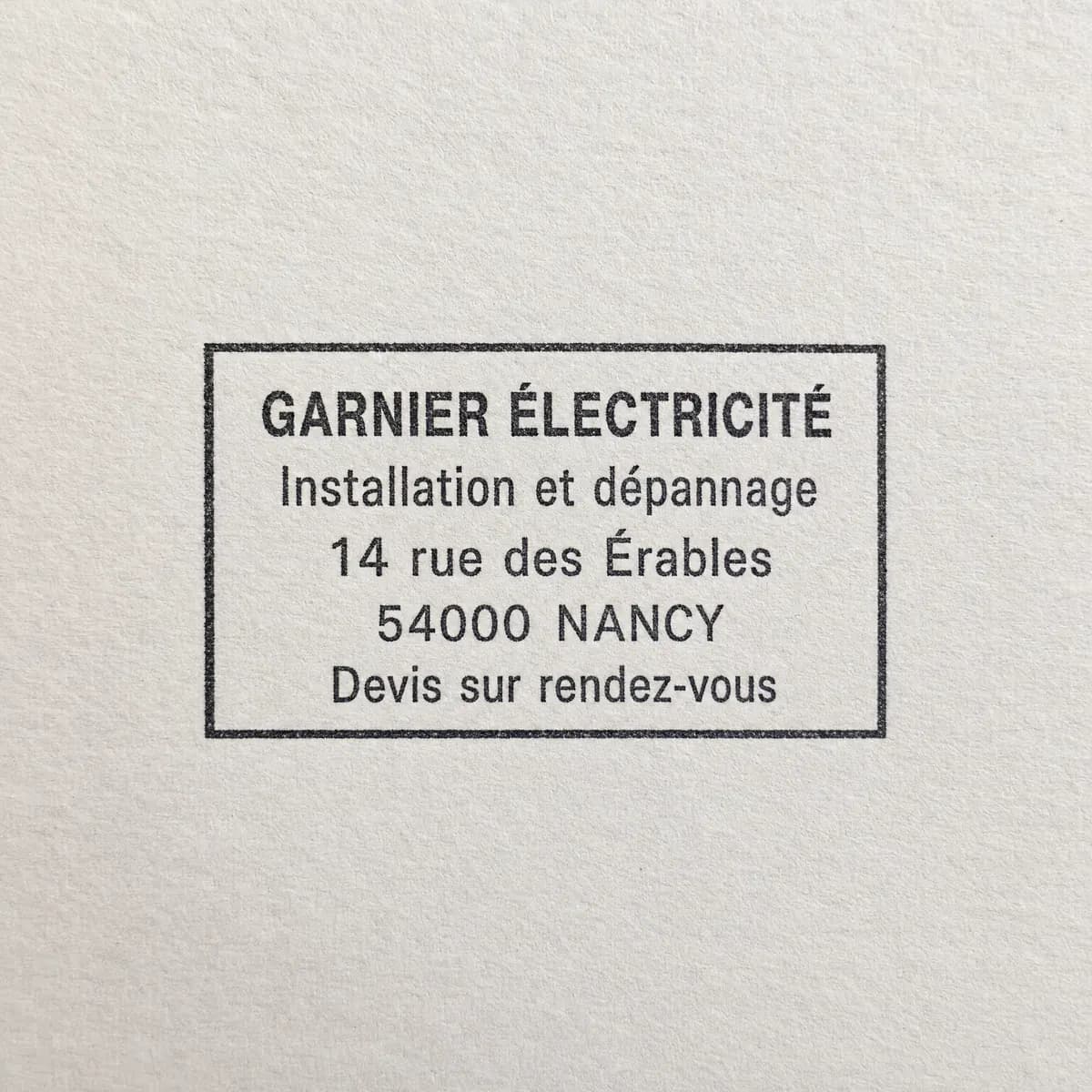 Électricien sur cinq lignes avec cadre : exemple d’empreinte à l’encre noire sur papier blanc
