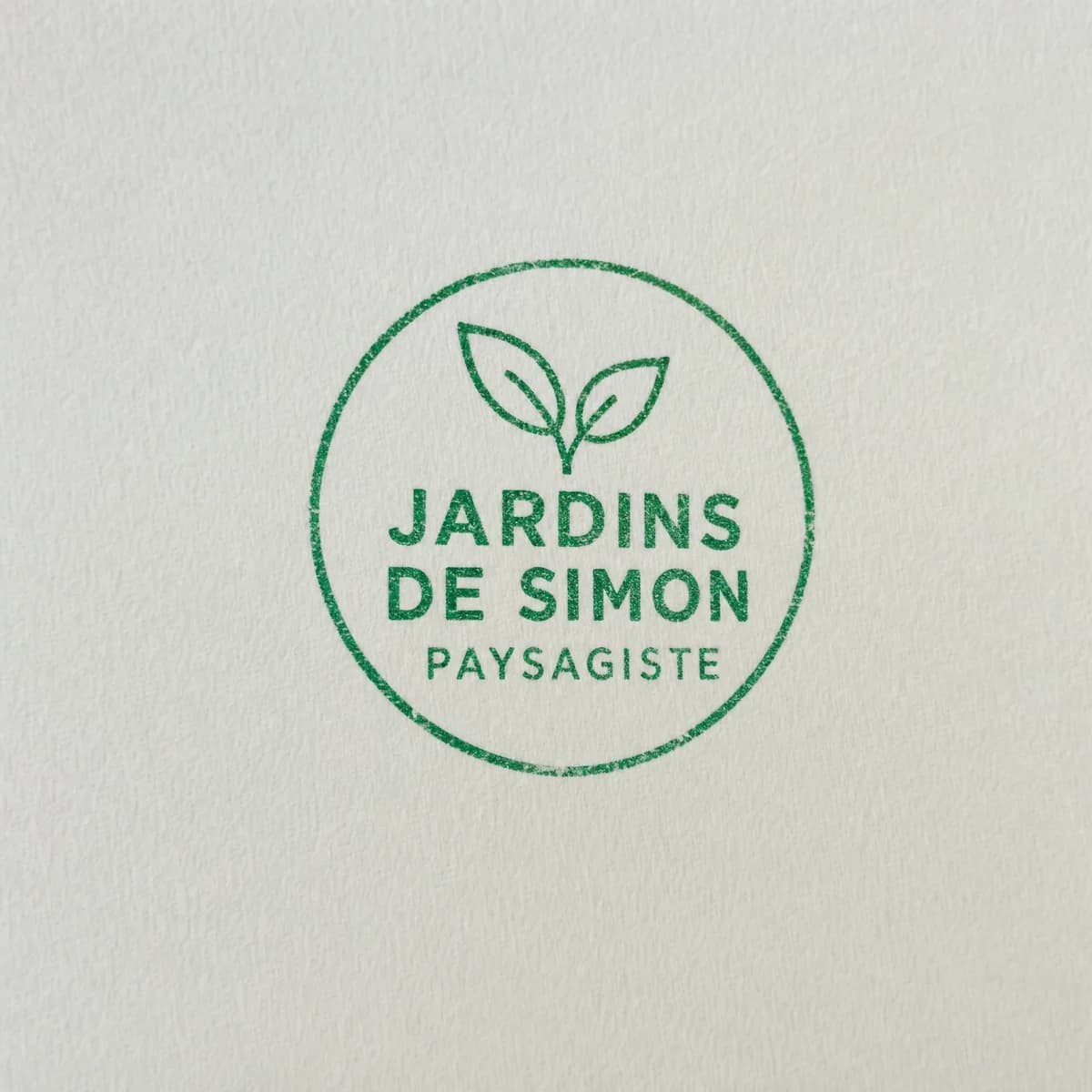 Paysagiste avec logo végétal : exemple d’empreinte à l’encre verte sur papier blanc