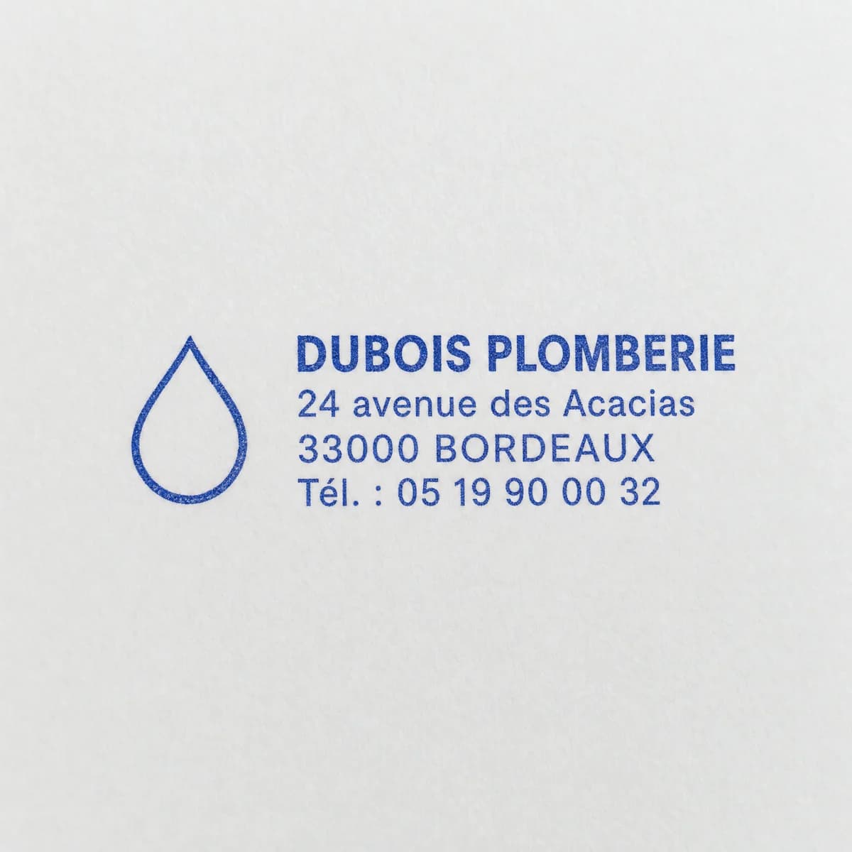 Exemple de personnalisation d’empreinte bleue : logo en forme de goutte à gauche des coordonnées fictives de Dubois Plomberie