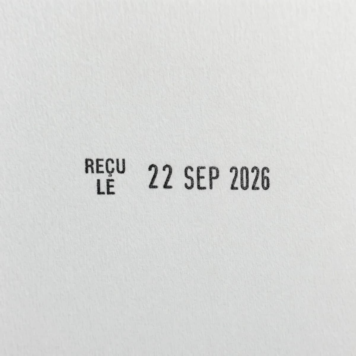Texte à gauche et date à droite : exemple d’empreinte à l’encre noire sur papier blanc