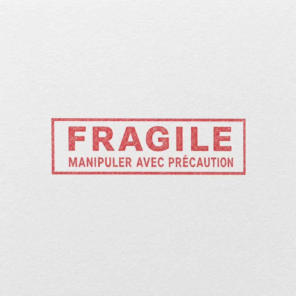 Mention Fragile avec cadre : exemple d’empreinte à l’encre rouge sur papier blanc