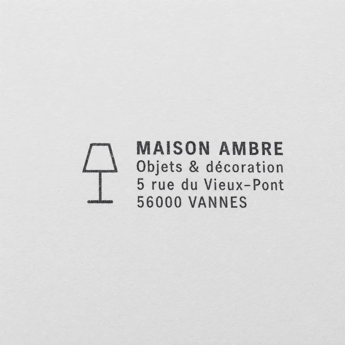 Boutique avec logo de lampe : exemple d’empreinte à l’encre noire sur papier blanc