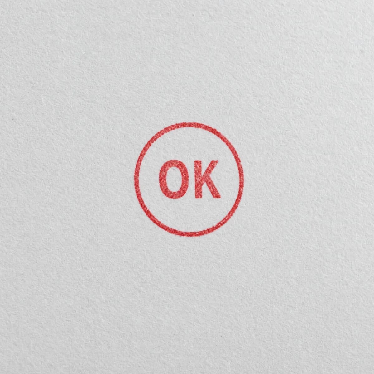 Mention OK dans un cercle rouge : exemple d’empreinte à l’encre rouge sur papier blanc